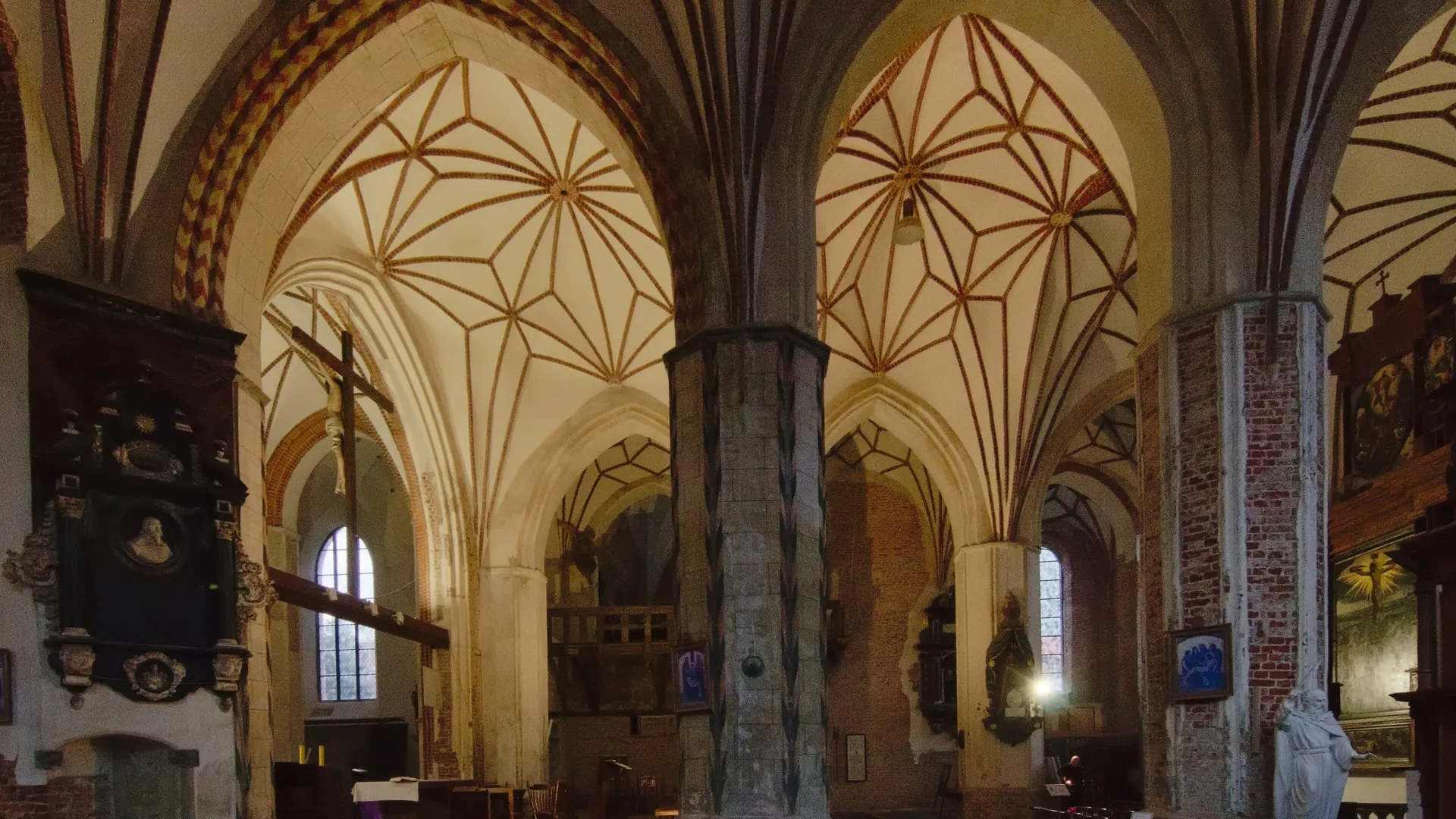 Star-shaped brick vaults and amber light inside St Catherine's Church in Gdańsk, photographed by day, not during a concert.