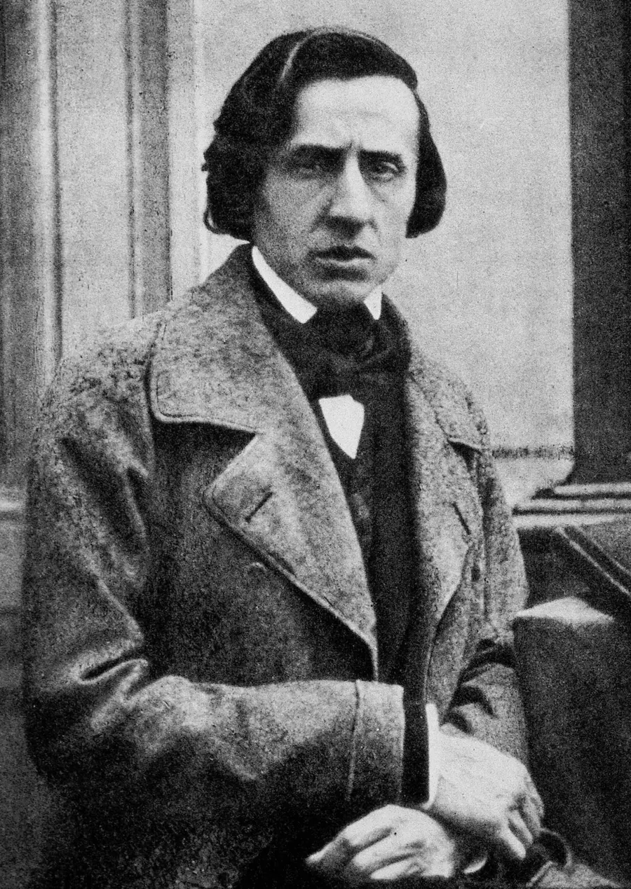 A grainy black and white photograph of Frédéric Chopin in a heavy coat and bow tie, taken in 1849